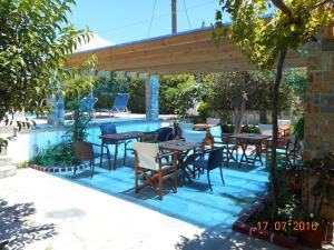 eine Terrasse mit Tischen und Stühlen neben einem Pool in der Unterkunft Guesthouse Christos in Skopelos