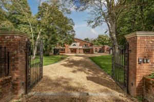 an entrance to a brick house with a gate at The Annex in Wimborne Minster