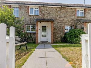 Una casa de ladrillo con un banco delante de ella. en 4 Bed in Westward Ho 46838, en Westward Ho