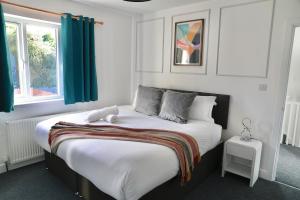 1 dormitorio con 1 cama blanca grande con cortinas verdes en Modern Spacious 3BR-Free Parking-Long Stay Discounts, en Maidstone
