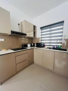 a kitchen with white cabinets and a sink and a window at Celestial Negombo Villa 85 in Negombo