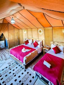 1 dormitorio con 2 camas en una tienda de campaña en Original Luxury Camp, en Merzouga