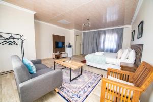 a living room with a bed and a couch at Tintswalo Elegant Apartments in Giyani
