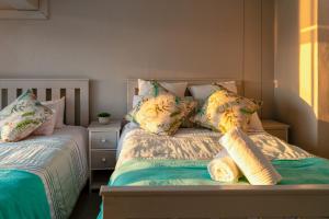 a bedroom with two beds with pillows at Port Owen Marina Starlight 20 by First Private Stays in Velddrif +23 photos