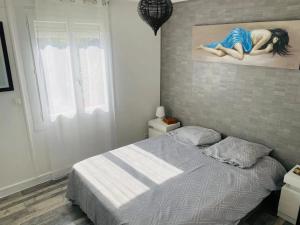 ein Schlafzimmer mit einem Bett und einem Gemälde an der Wand in der Unterkunft Villa accueillante avec piscine à Saint-Paul-et-Valmalle in Saint-Paul-et-Valmalle + 13 Fotos