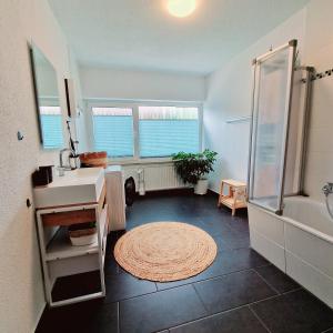 a bathroom with a tub and a sink and a shower at Holle - Land Holidays, parterre Ferienwohnung in Lichtenau +37 photos