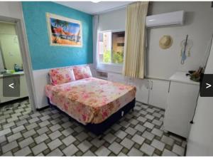 a small bedroom with a bed and a window at Apartamento em Maceio, uma quadra da praia in Maceió