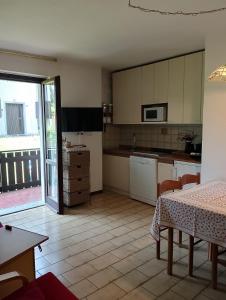a kitchen with white cabinets and a table with a tableablish at Piera' s House in Caderzone