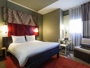 a hotel room with a large bed and a chair at ibis Bordeaux Centre - Gare Saint-Jean in Bordeaux