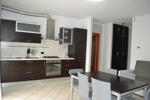 a kitchen with a table and chairs and a kitchen with black cabinets at Appartamento ai Noci in Padova +2 photos