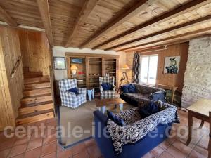 een woonkamer met blauwe banken en een tafel bij La Villa de la Clairiere in Le Bois-Plage-en-Ré