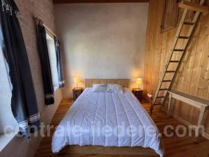 een slaapkamer met een bed, 2 lampen en een ladder bij La Villa de la Clairiere in Le Bois-Plage-en-Ré