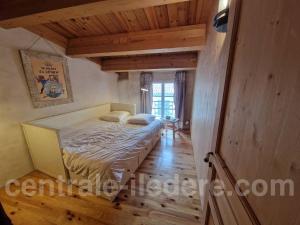een slaapkamer met een bed in een kamer met houten plafonds bij La Villa de la Clairiere in Le Bois-Plage-en-Ré