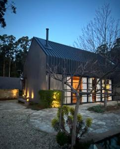 una casa con un tetto nero e luci di The Barn at Stonewalls - Farm stay in 25 acres a Musk