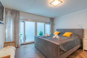 a bedroom with a large bed with a large window at Oude Dijkje in De Koog