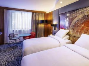 a hotel room with two beds and a table at Hotel Mercure Toulouse Centre Compans in Toulouse +171 photos