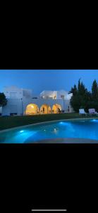 a view of a building with a pool in front of it at RDC Villa avec Jardin & Piscine Privée in El Aouina Station