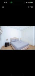 a bedroom with a large white bed with two lamps on it at RDC Villa avec Jardin & Piscine Privée in El Aouina Station +1 photo