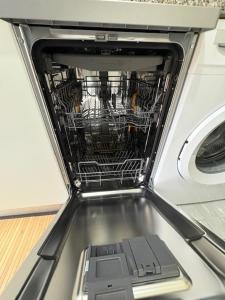 Un lavavajillas con la puerta abierta y los platos dentro. en Miky House, en Turín