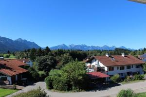 a group of houses with mountains in the background at Apartment Alpenblick 10, Halblech im Allgäu, Bergblick pur - NEUERÖFFNUNG! in Berghof