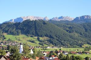 a village in a valley with mountains in the background at Apartment Alpenblick 10, Halblech im Allgäu, Bergblick pur - NEUERÖFFNUNG! in Berghof +13 photos