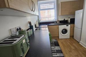a kitchen with a stove and a washer and dryer at 1 Bed - Sleeps 4 - City Centre in Wolverhampton