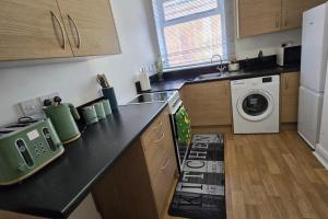 a kitchen with a counter top with a washing machine at 1 Bed - Sleeps 4 - City Centre in Wolverhampton