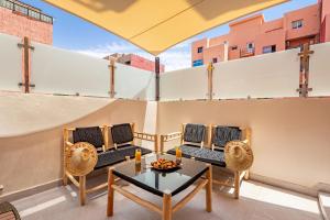 a patio with chairs and a table on a balcony at NOUVEAU à Marrakech in Marrakech