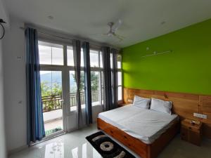 a green bedroom with a bed and a large window at The Kiwi Shadow Guest House in Almora