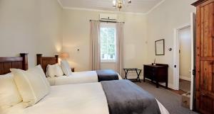 a hotel room with two beds and a window at Karoo House Collection - 111 Cradock in Graaff-Reinet