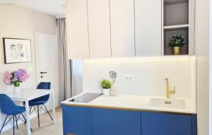 a kitchen with a sink and a table with blue chairs at Studio Apartment Jasna 1 by Villas Guide in Rovinj