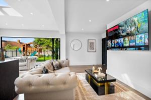 a living room with a couch and a tv at Superb Luxury 3 Bedroom House - Garden - Parking - Outdoor Playground 17P in Birmingham