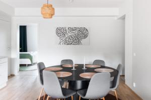a dining room with a black table and chairs at Cosy family apartment with parking, sauna and balcony in Jyväskylä +11 photos