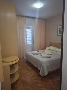 a small bedroom with a bed and a window at Zvjezdana in Kampor