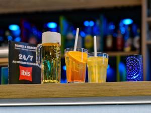 three glasses of beer sitting on a bar at ibis Hotel Frankfurt Messe West in Frankfurt/Main