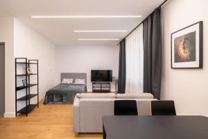a living room with a couch and a bed at Cozy Dzintaru apartment - Steps from Forest and Sea in Jūrmala