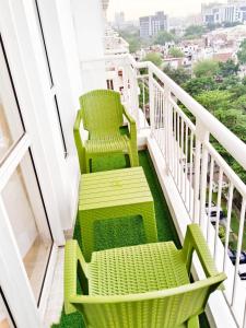 two green chairs sitting on a balcony at Lucknow express by origin Suites DLF MY PAD near Gomti Nagar Railway Station Lucknow in Lucknow