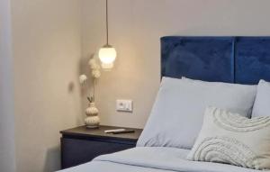 a bed with a blue headboard and a vase on a table at Apartment Jasna 2 by Villas Guide in Rovinj