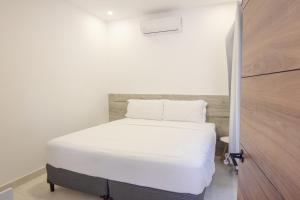 a small bedroom with a white bed in a room at Somnara Bosque Tropical in Talamanca +1 photo