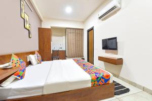 a bedroom with a large bed and a television at FabExpress Fusion Stays in Indore