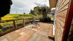 a patio with a table and chairs and a fence at Entick Lodge No 4 in Dunswell