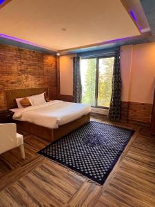 une chambre avec un lit et une grande fenêtre dans l'établissement Green Executive Hotel, à Nathia Gali