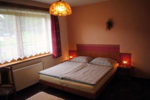 1 dormitorio con cama, ventana y lámpara de araña en Pension B&B, en Vrchlabí
