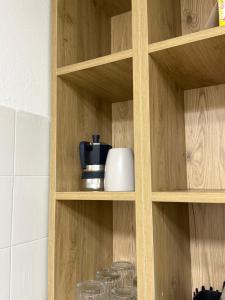 a wooden shelf with a coffee pot and glasses at Regina del bosco in Ronzone