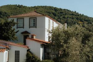 una casa blanca con una montaña al fondo en Special Farmstay, Faia-Guarda, en Faia