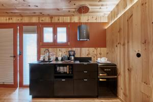 a kitchen with wooden walls and a black stove top oven at Pincelo Nature in Pincelo