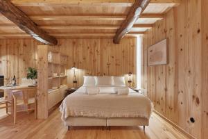 a bedroom with a bed and a wooden wall at Pincelo Nature in Pincelo