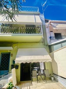 a building with a balcony with chairs and a table at Sophia Loft Luxury Stay with Parking in Athens