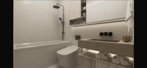 a white bathroom with a toilet and a sink at Luxury pick Hotel in Alpharetta