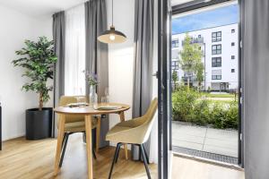 a dining room with a table and chairs and a window at cruwzo I Regensburg Towers - Design Apartments in Regensburg
